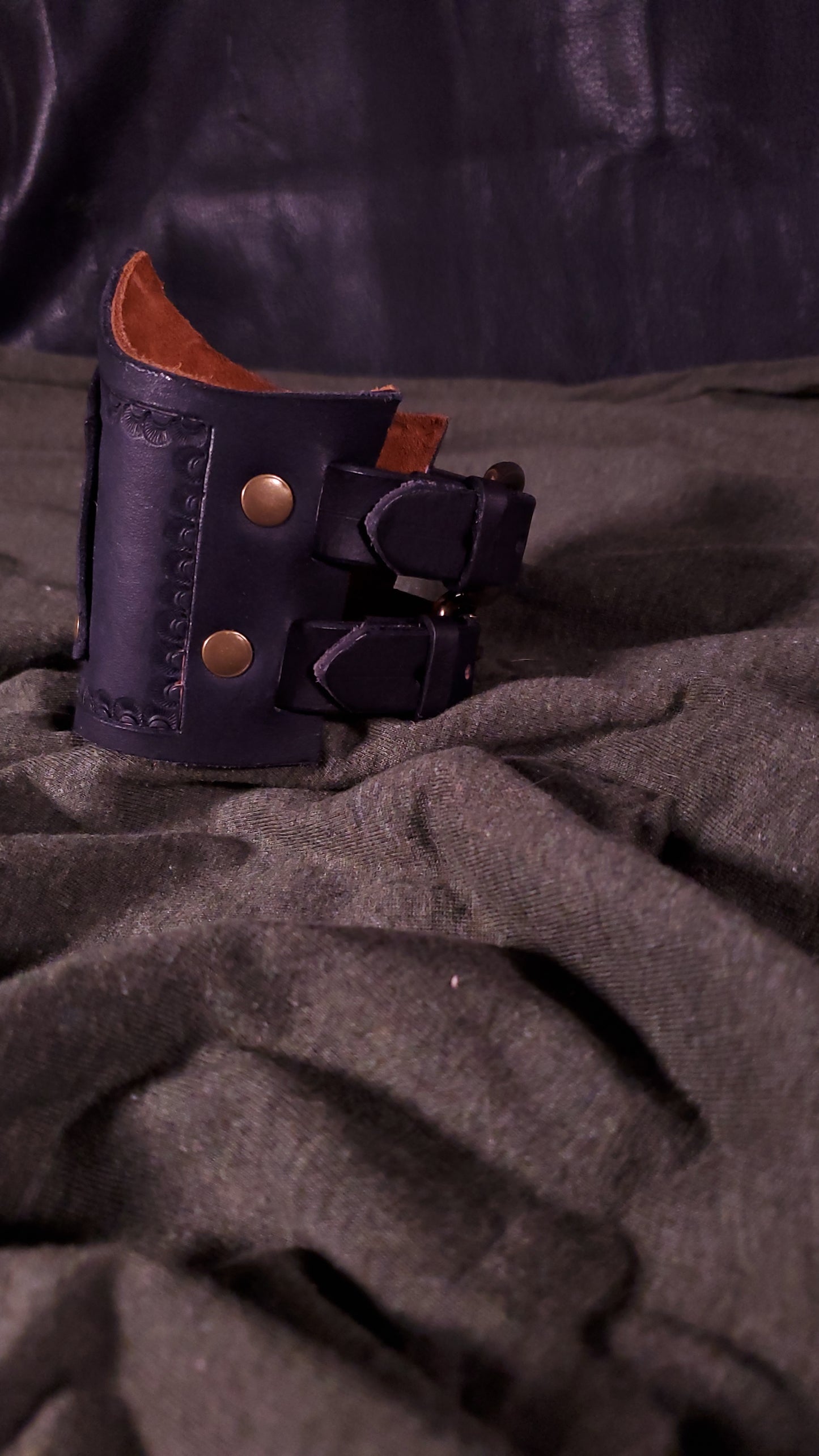 Black Cuff with a panel riveted onto it that has a mjolnir or thors hammer stamped onto it