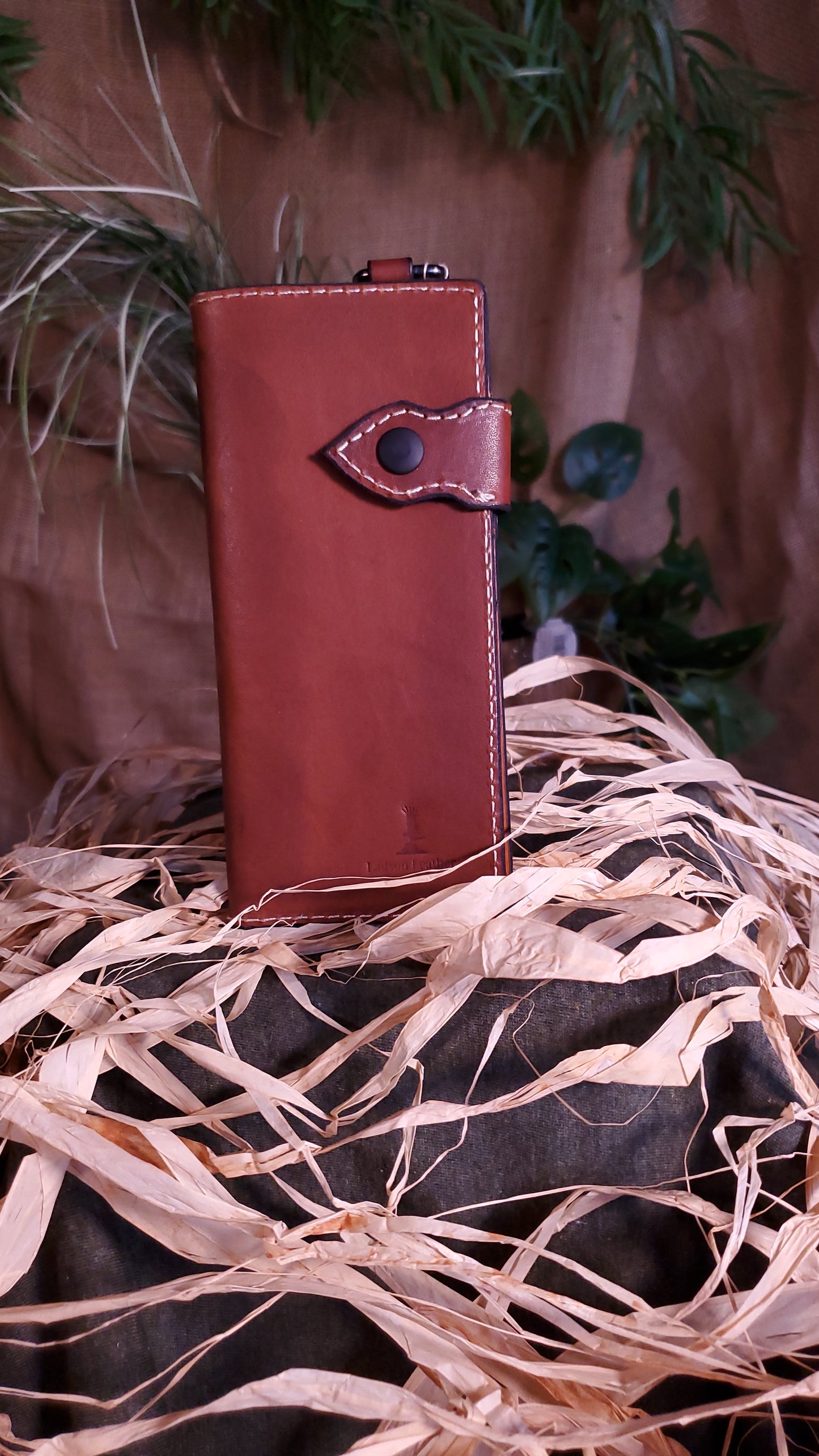 Exterior of the biker wallet with cream colored stitching, black hardware and a rich dark brown colored leather