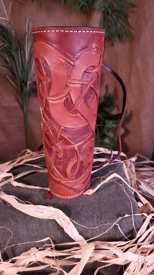 Front view of the small Bracer/arm guard. Showcasing the tooled design, as well as the mahogany color and cream colored stitching.