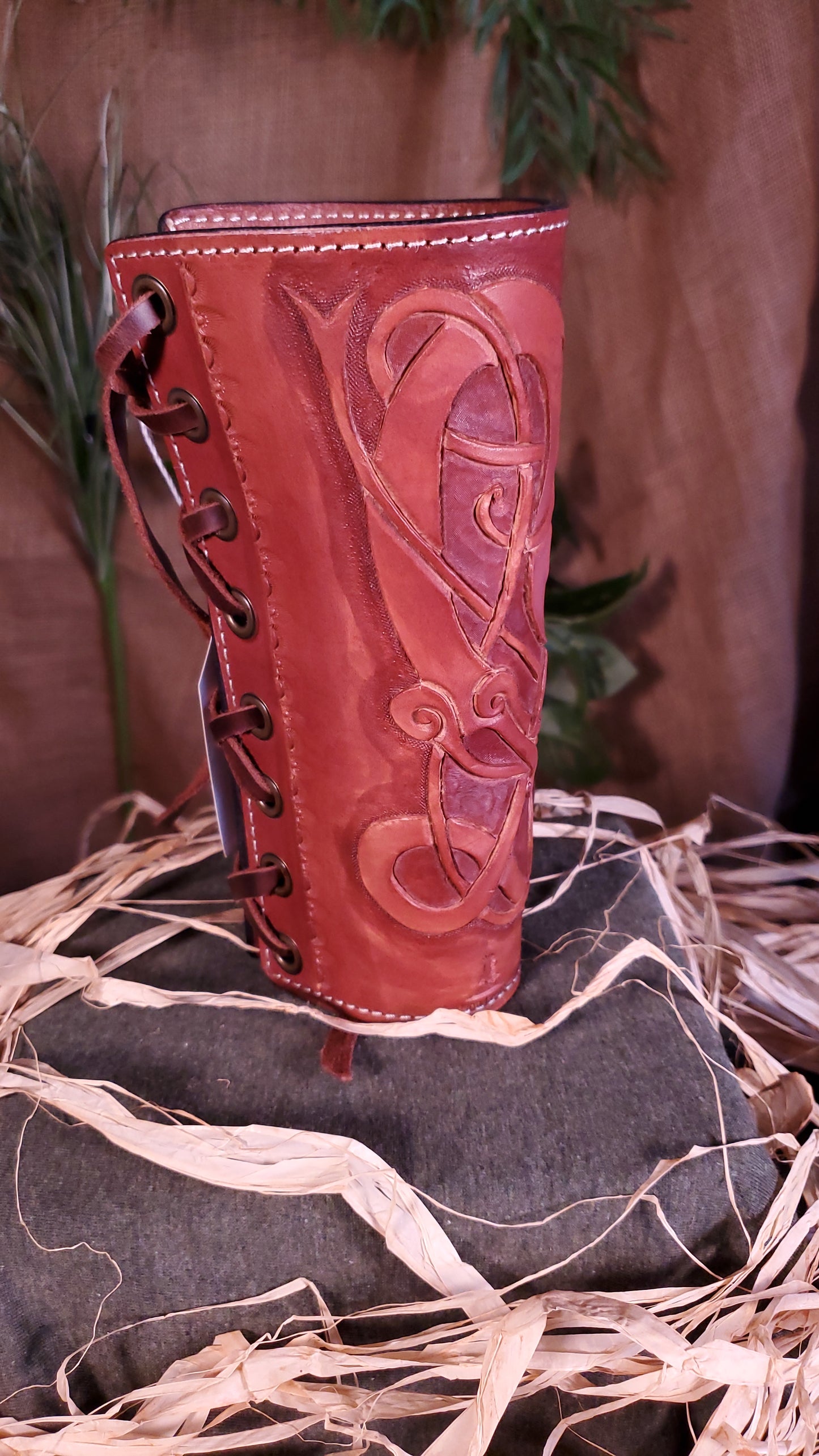 Side view of the large Bracer/Arm Guard. Showcasing the border stamps, as well as the lace and the grommets the lace goes through