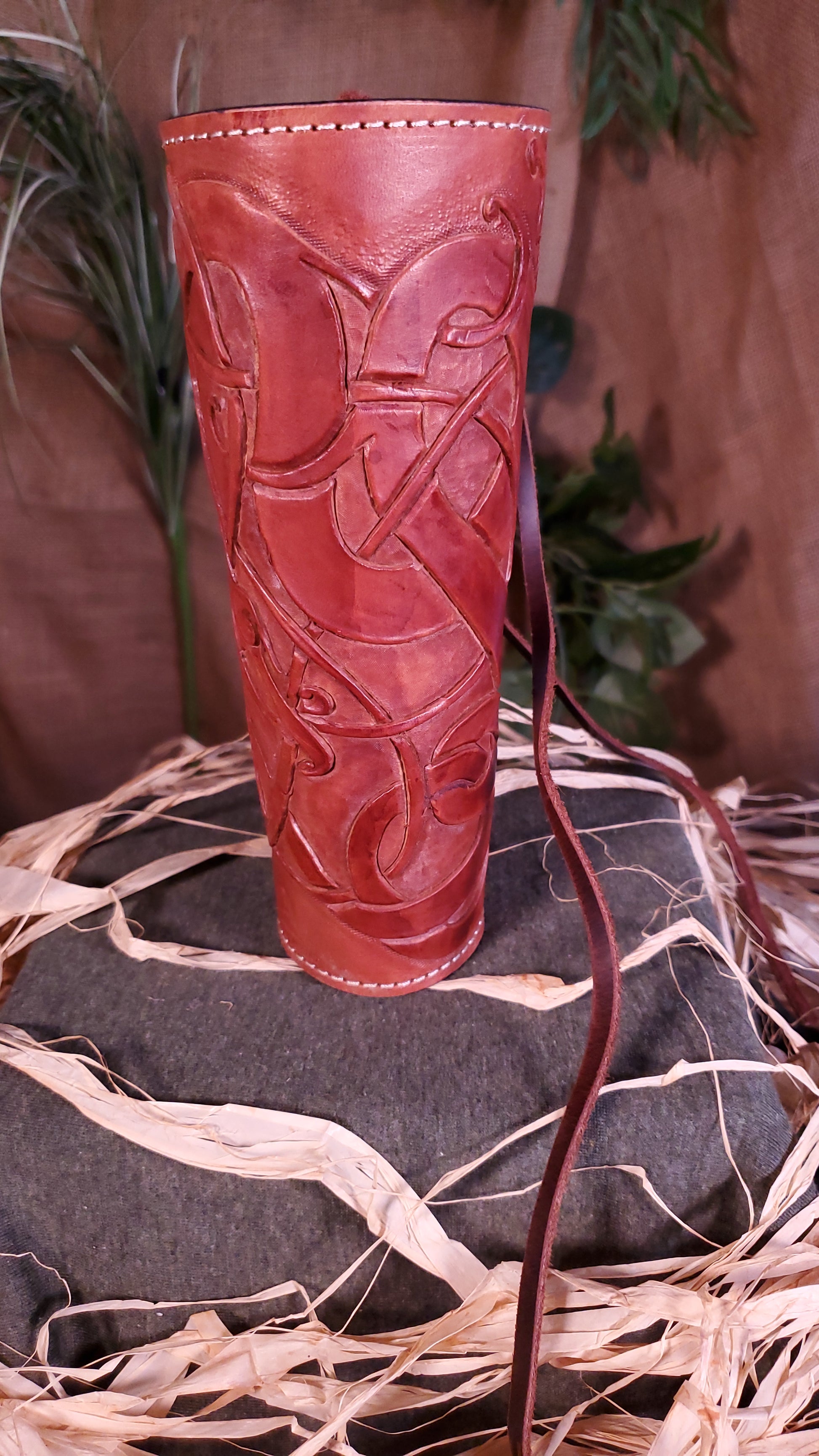 Front view of the Large Bracer/arm guard. Showcasing the tooled design, as well as the mahogany color and cream colored stitching.