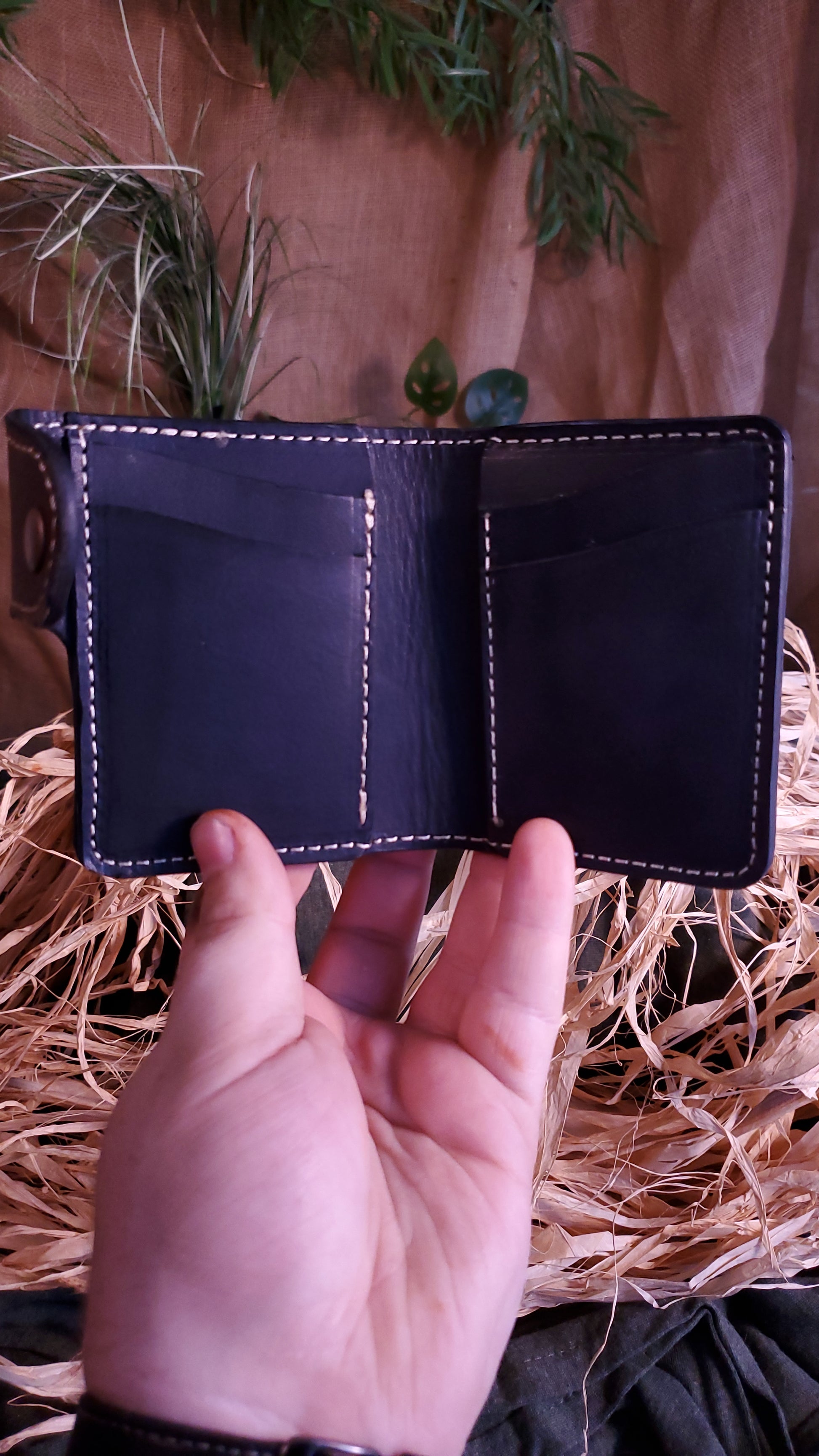 Interior of the snap style wallet, featuring 4 card slots, 2 on each side, as well as 2 hidden pockets behind the card slots, 1 on each side