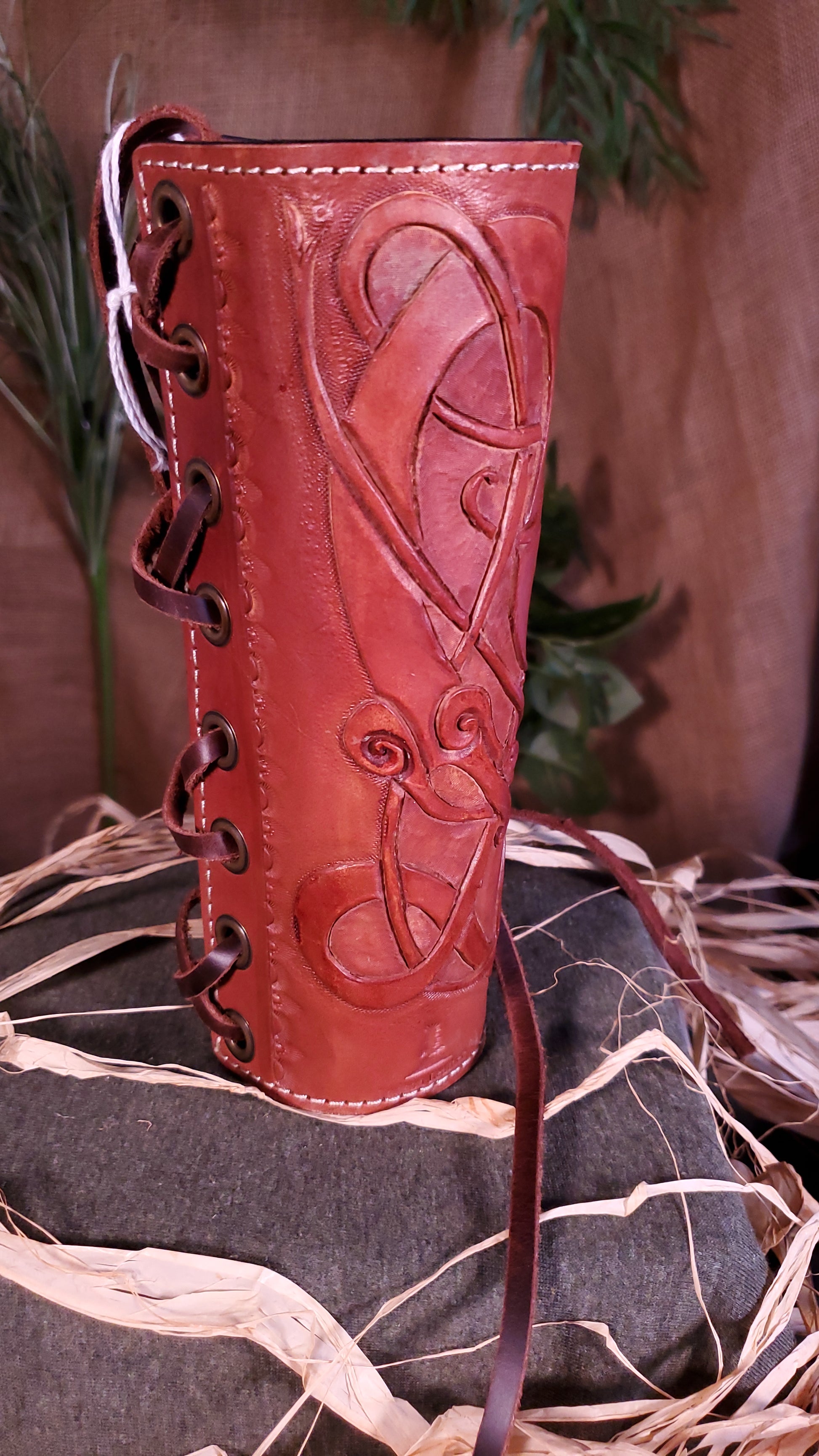 Side view of the small Bracer/Arm Guard. Showcasing the border stamps, as well as the lace and the grommets the lace goes through